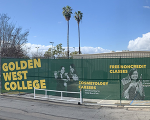 A long GWC green fence wrap next to parking lot.
