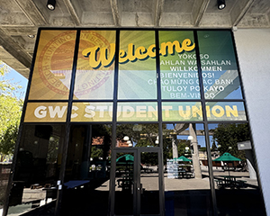Window clings on the building window says Welcome, GWC Student Union