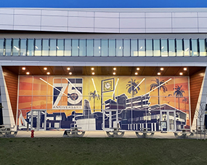 A large orange and blue window cling covering a side of a building. Text: 75th Anniversary.